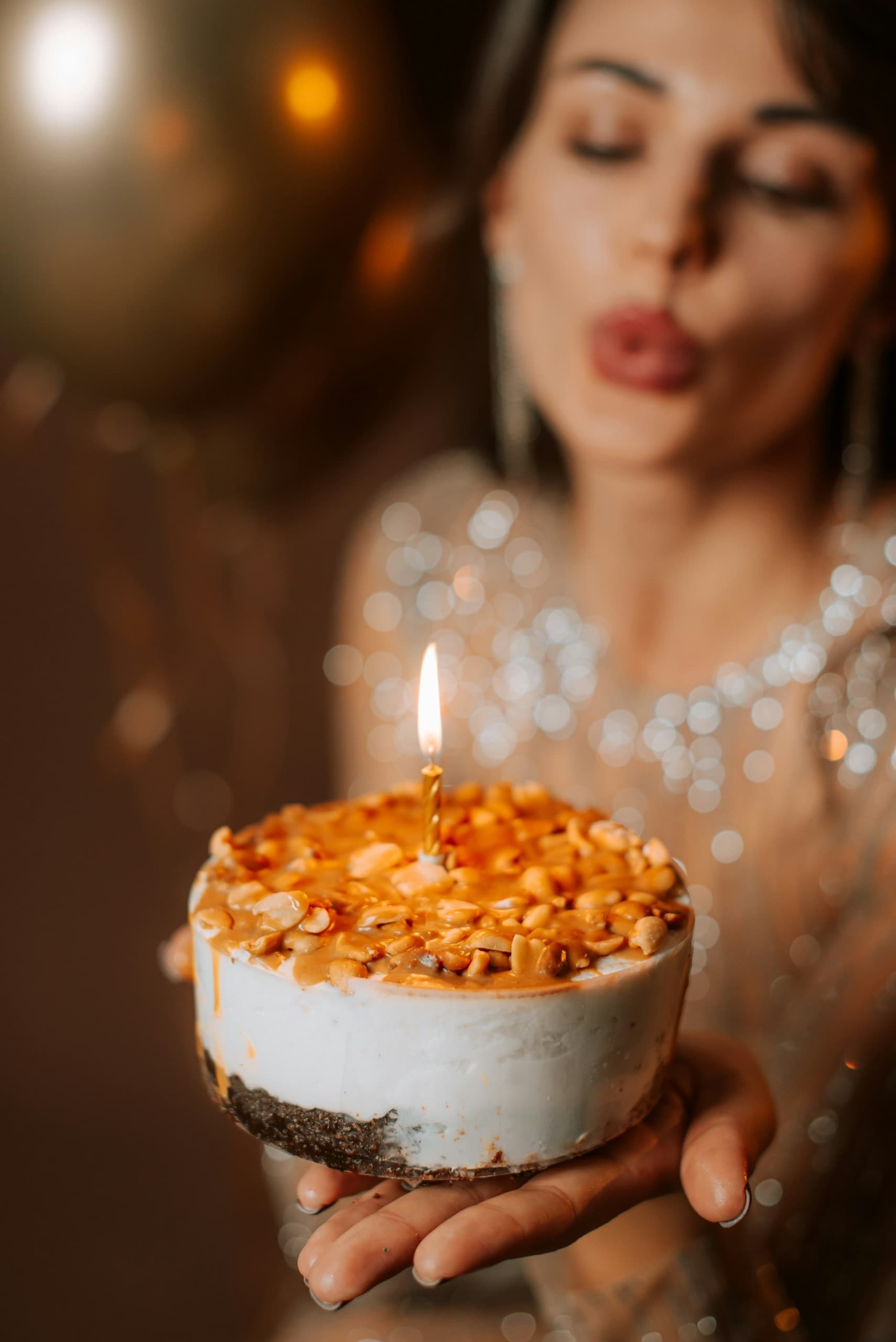 Personne souffle bougie d'anniversaire sur gâteau.